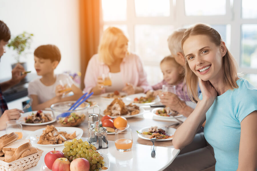 smiling woman sits at table with family